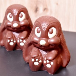 Handgegossene Osterhasen "Mamma Mia" aus Milchschokolade, aufgereiht nebeneinander. Das Foto stammt von Chani Schoggi.