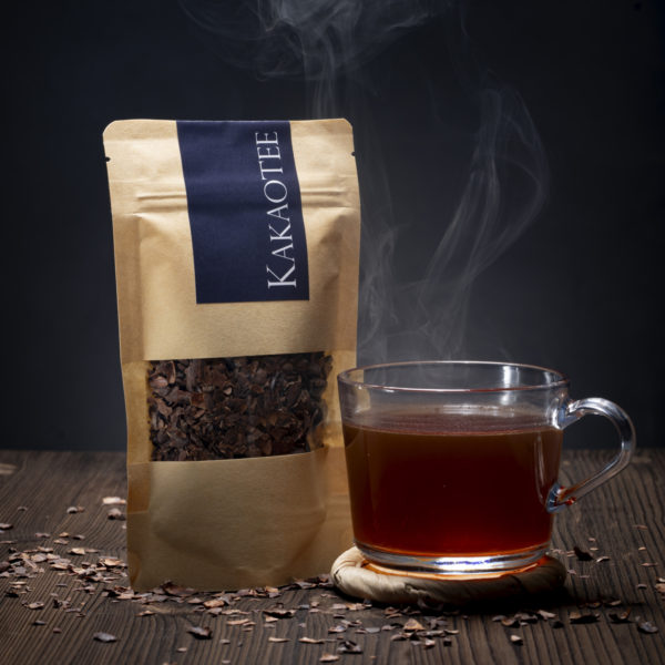Eine Tasse und ein Beutel mit Kakaoschalentee aus den Schalen der Kakaobohnen | Bean to Bar Schokoladenmanufaktur Chani Schoggi aus Ebikon