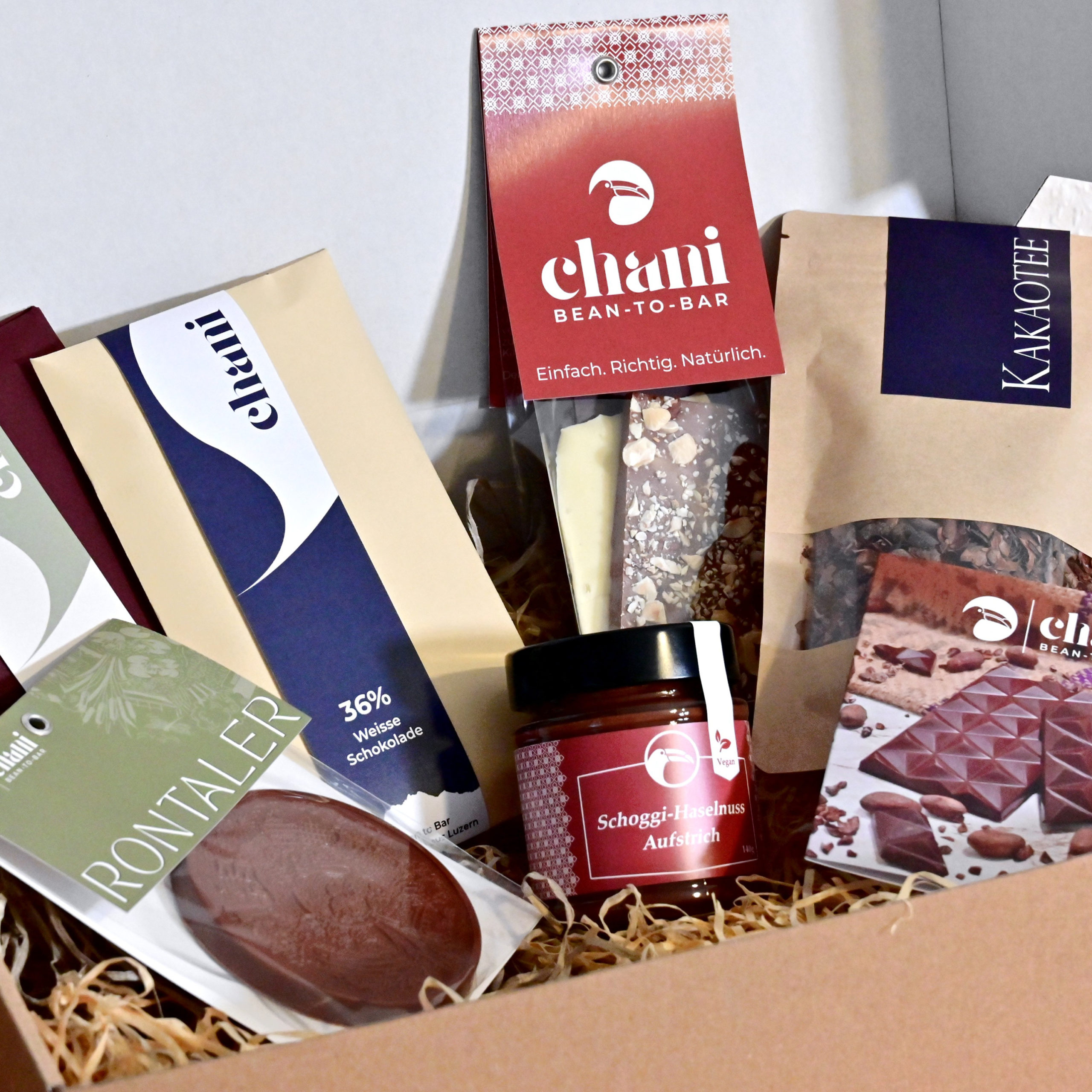 Eine Geschenkbox voller Schoggi-Spezialitäten zum Versenden als feines Schokoladengeschenk. Hergestellt von Chani Schoggi KLG in Ebikon/Luzern.