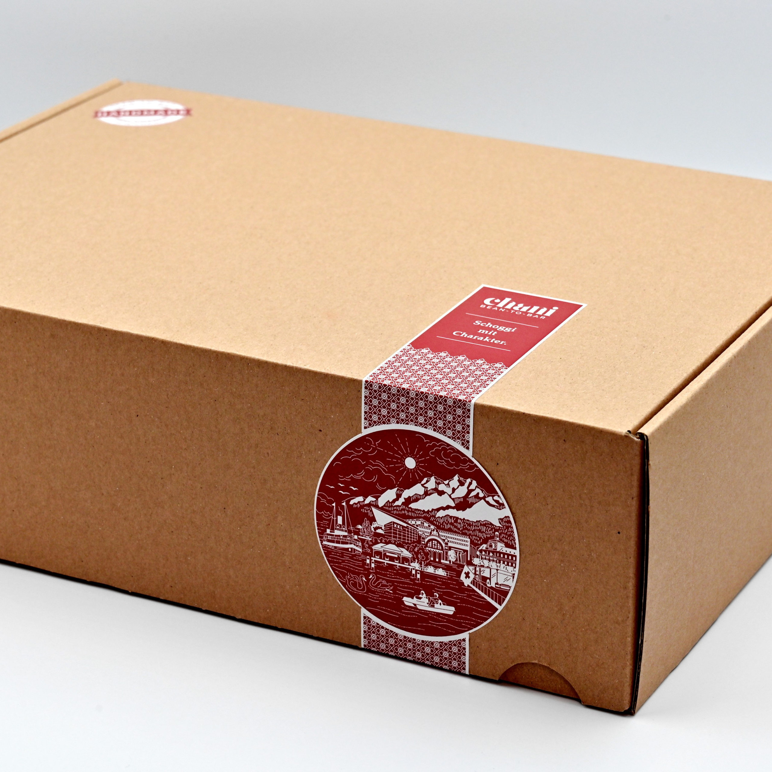 Geschenkbox «Aficionado» | Chani Schoggi Eine Geschenkbox voller Schoggi-Spezialitäten zum Versenden als feines Schokoladengeschenk. Hergestellt von Chani Schoggi KLG in Ebikon/Luzern.