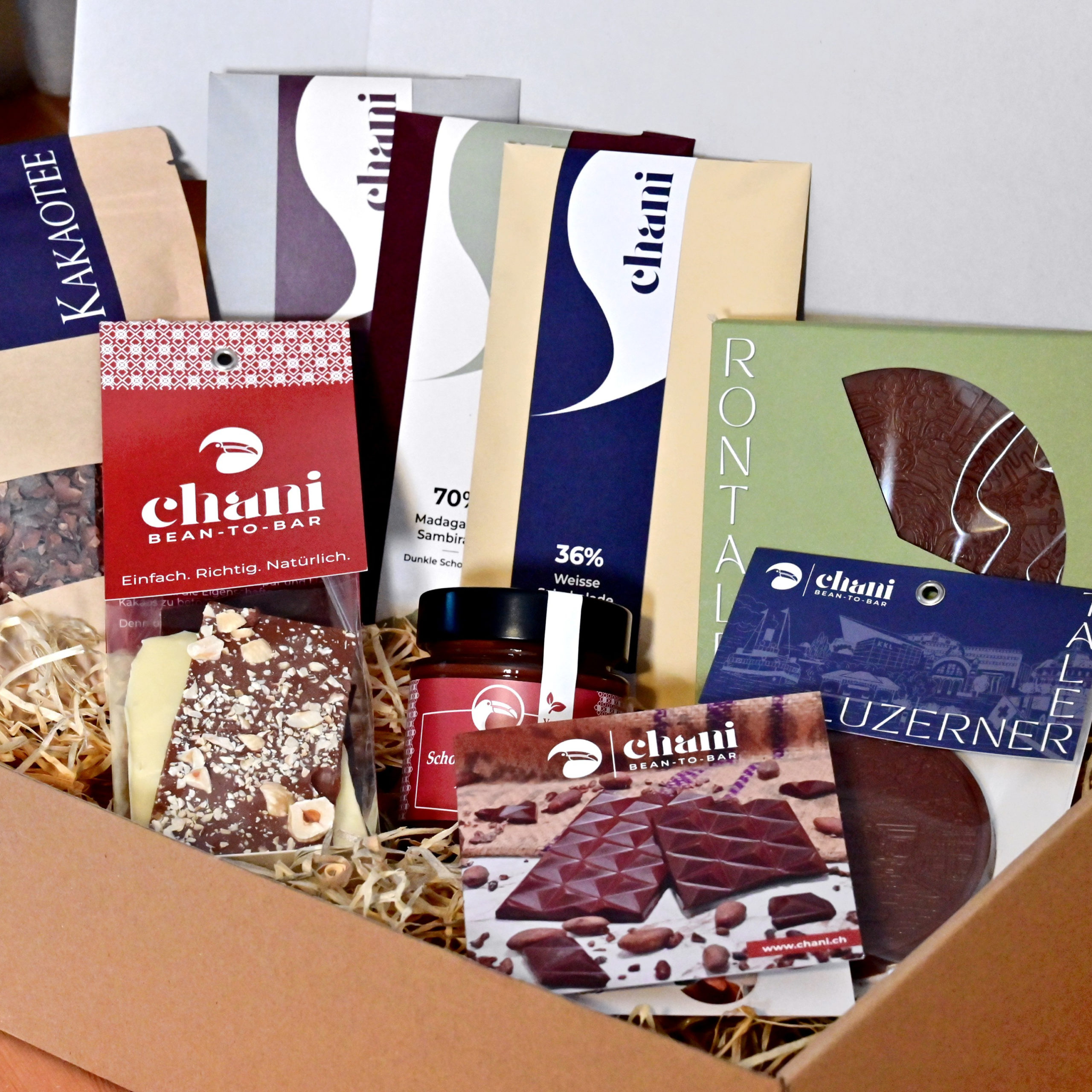 Geschenkbox «Aficionado» | Chani Schoggi Eine Geschenkbox voller Schoggi-Spezialitäten zum Versenden als feines Schokoladengeschenk. Hergestellt von Chani Schoggi KLG in Ebikon/Luzern.