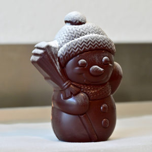 Freddy, der charmante Schoggi-Schneemann aus dunkler Schokolade – von Hand gegossen und winterlich bestäubt. Ein süsser Genuss für kalte Tage und festliche Momente.